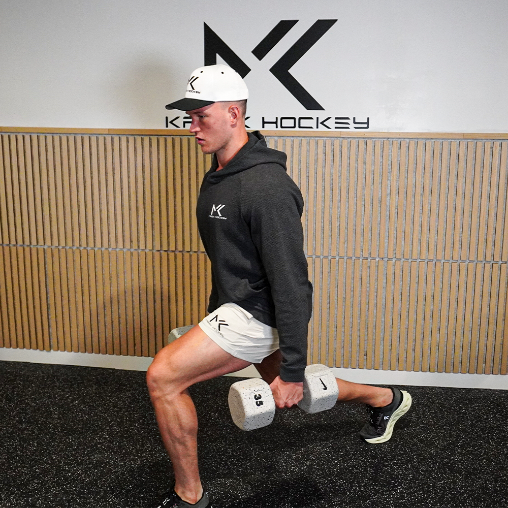 Matyáš Kašek performing a lunge with dumbbells in a gym